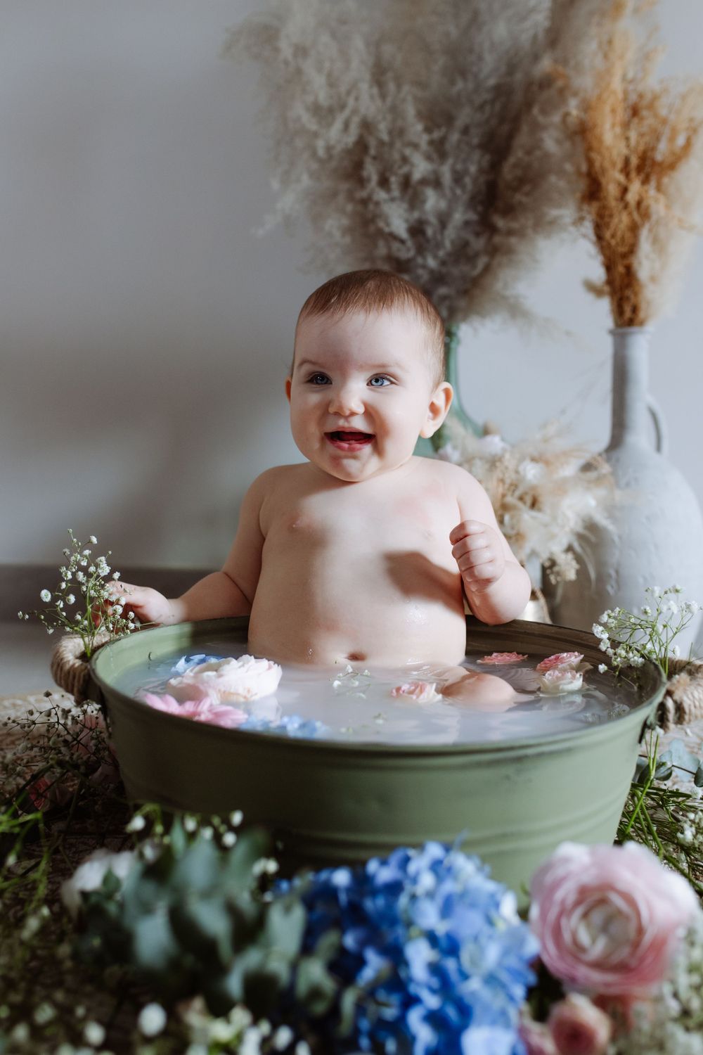 Bébé souriant dans une séance bain de lait à domicile, photographe Yvelines