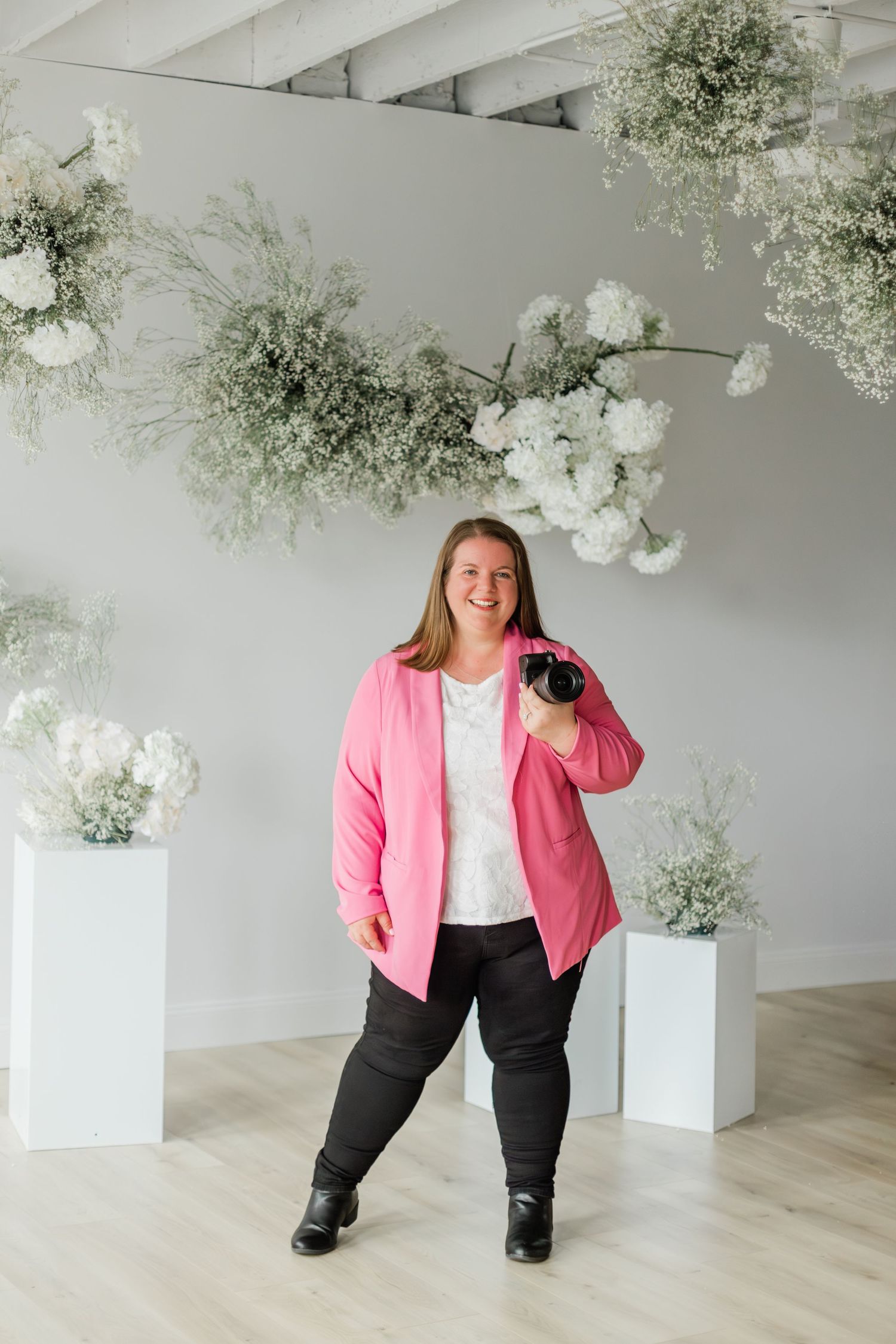Alex Lacey, Toledo senior photographer smiling in natural studio lighting