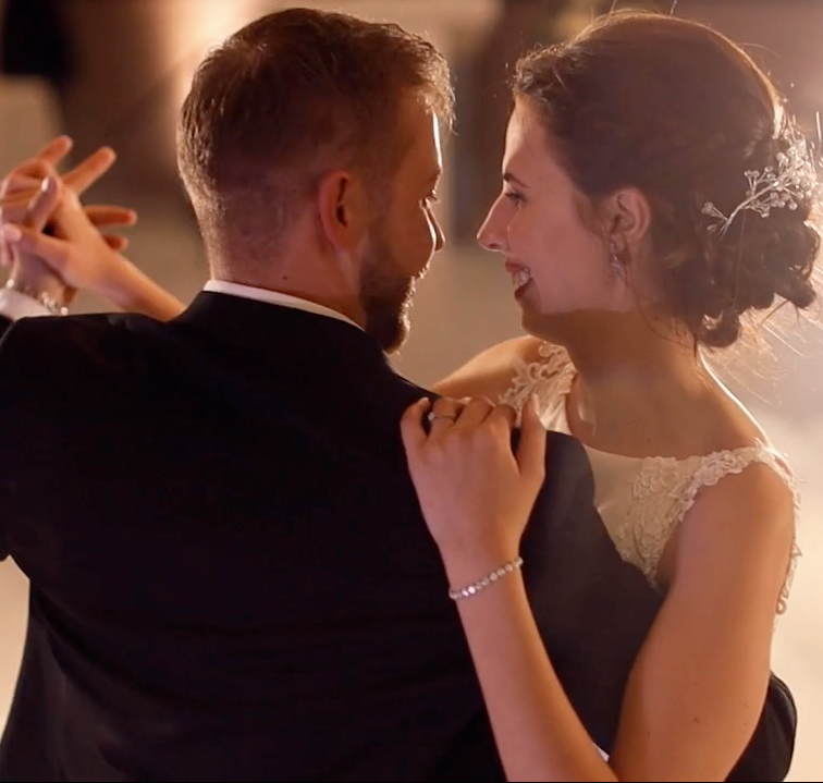 Elegant couple sharing romantic dance moment in warm indoor lighting.