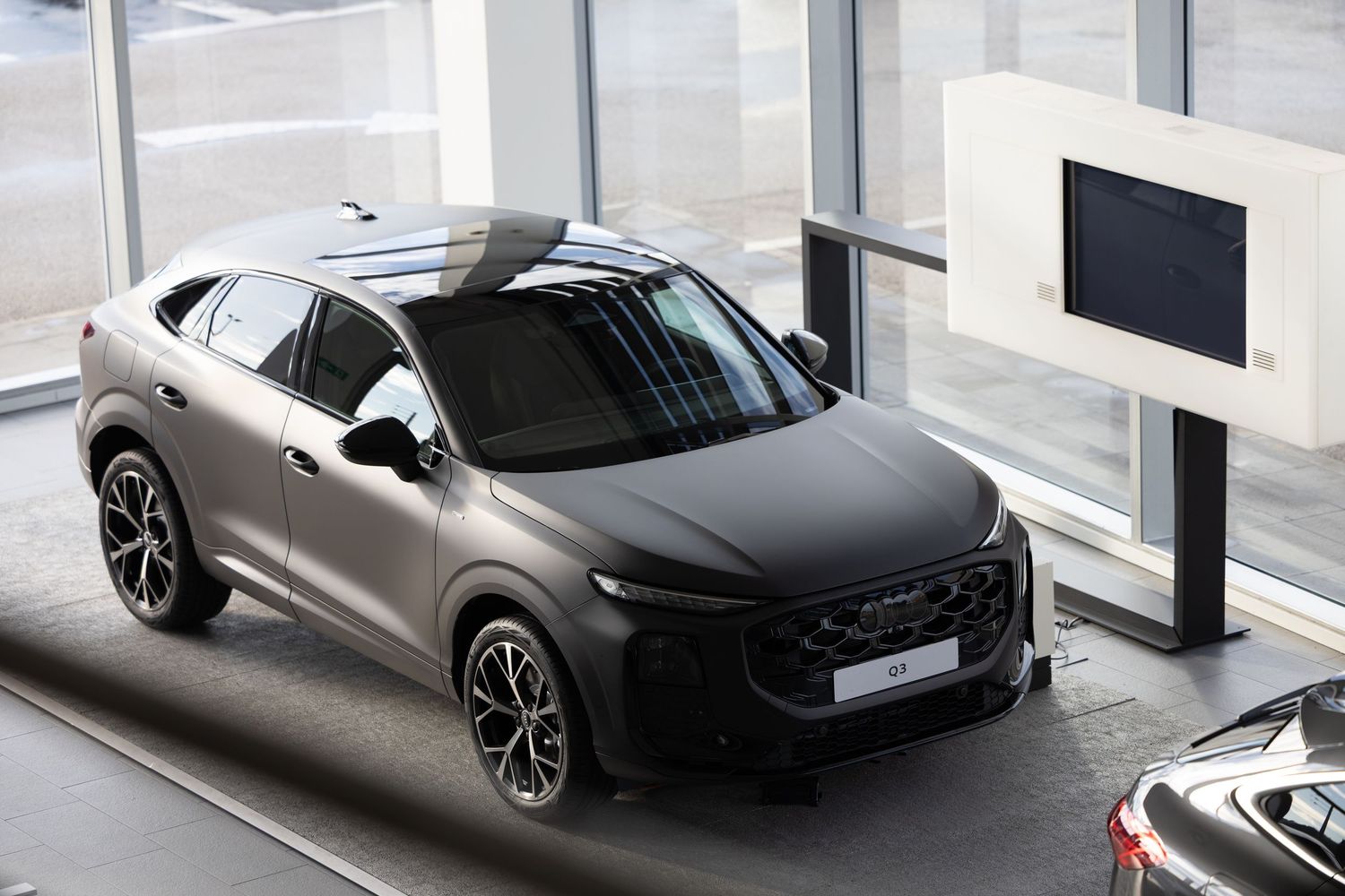 Dark grey DS luxury SUV coupe displayed in a modern car showroom with large windows and polished floors.