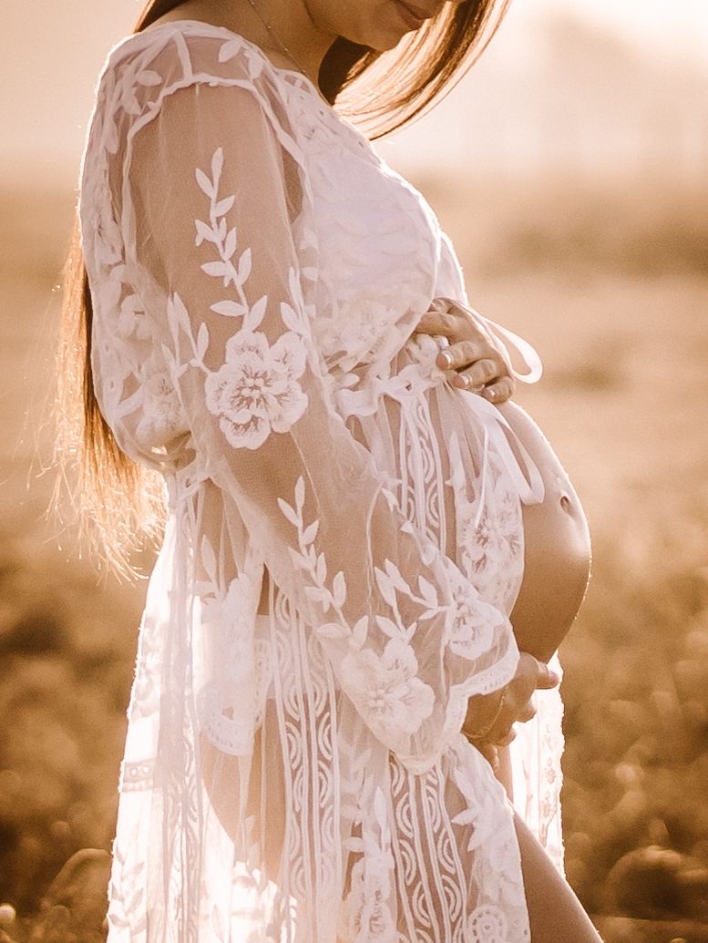 Fotografía de embarazo con vestido de encaje en exterior al atardecer en Girona.