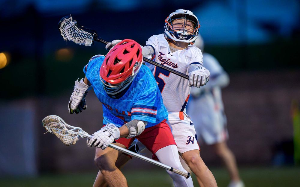 Hershey Trojans defender and Red Land Patriots in close play, boys lacrosse by Deanna Fox, SportsFox Photography based in Hershey PA