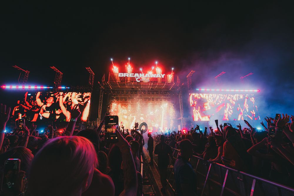 Crowd cheering at Breakaway Music Festival night concert with vibrant stage lights and LED screens.