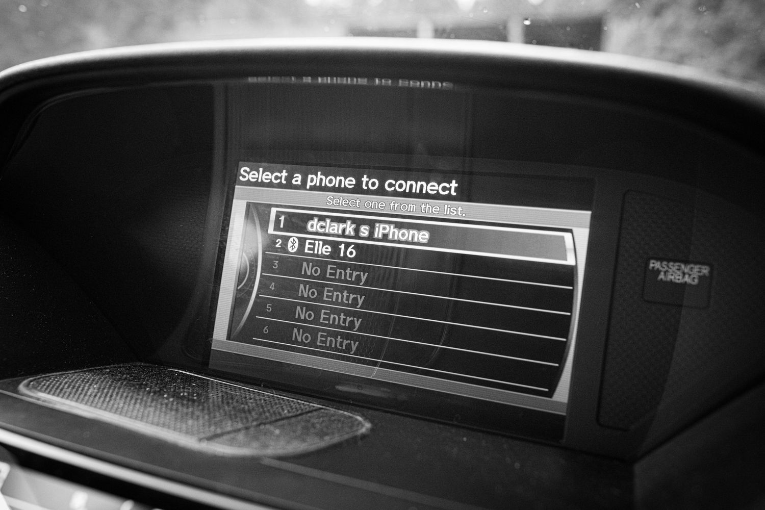 Car dashboard screen displaying Bluetooth phone connection menu with dclark s iPhone listed as available device.