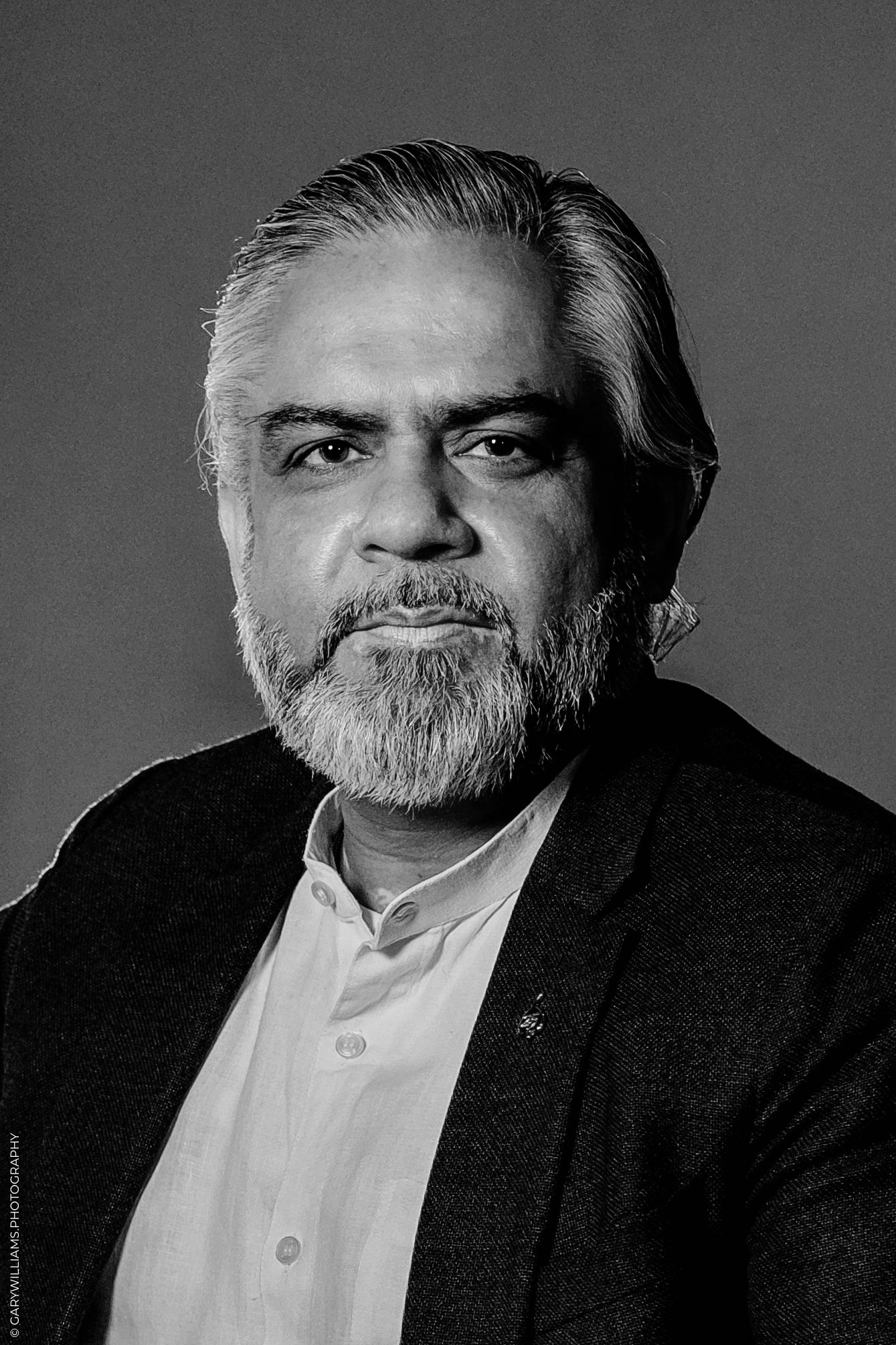 Black and white portrait of a bearded middle-aged man in a blazer, professional headshot photography.