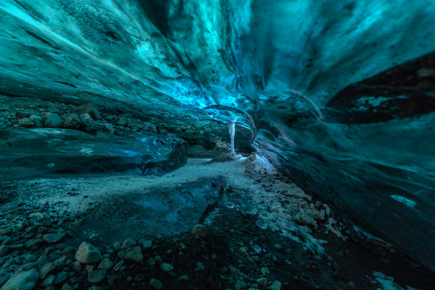 Ethereal blue ice cave interior glowing with stunning turquoise light inside an Icelandic glacier.