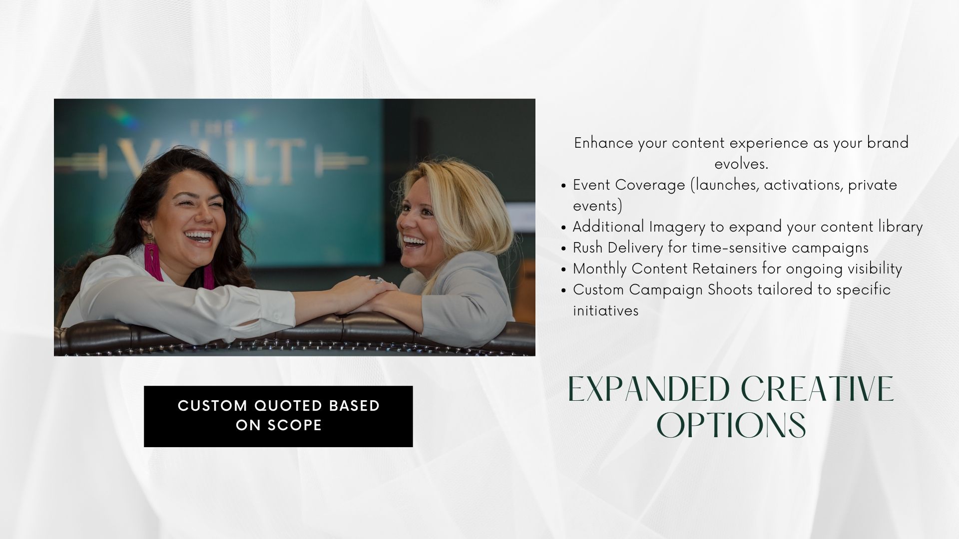 Two women smiling and embracing at a branded event, promoting expanded creative options and custom campaign shoots.
