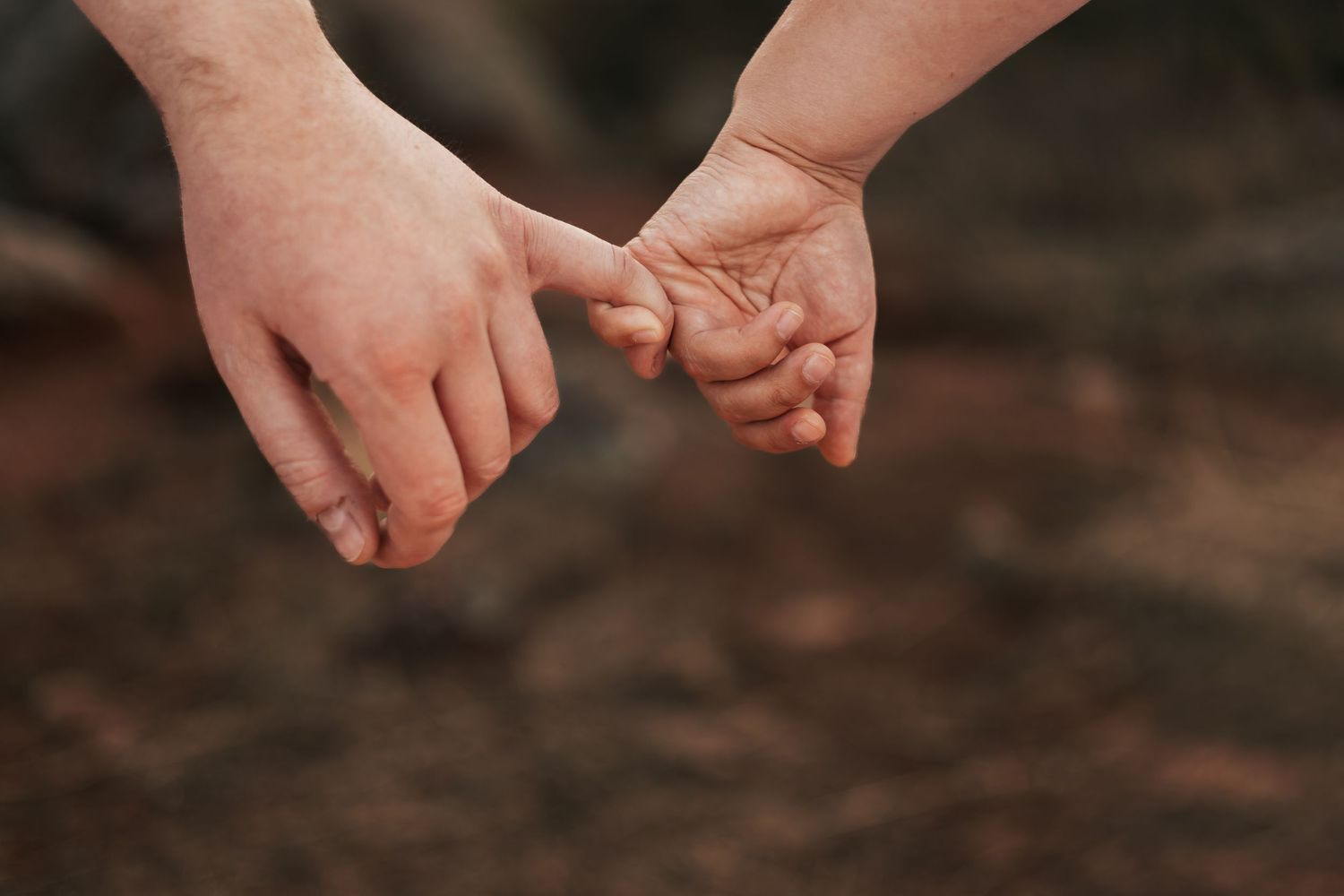 Two people gently holding hands outdoors, symbolizing love and connection | Couple Photos in Boulder, Colorado