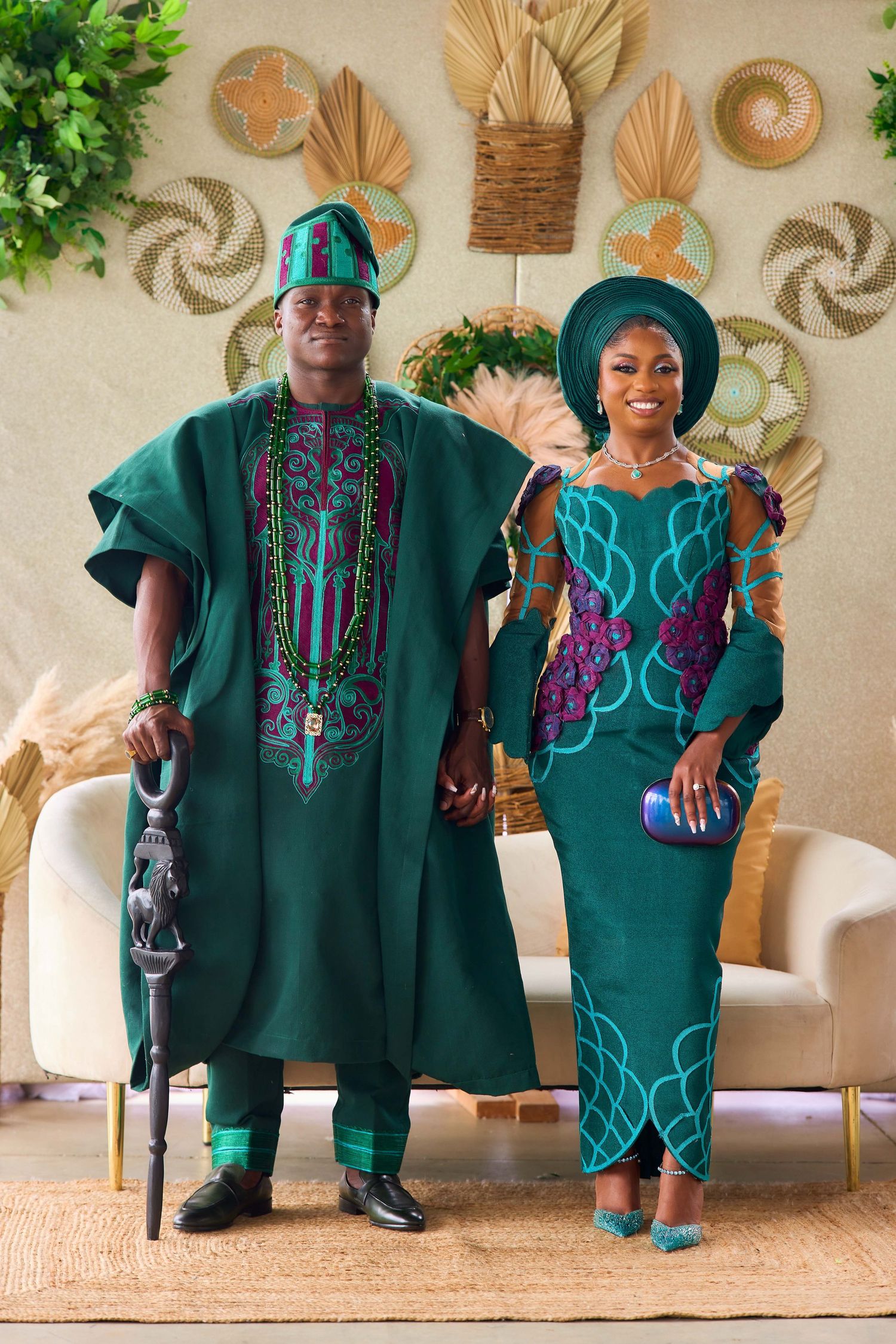 Nigerian couple in matching emerald green traditional Yoruba attire, agbada and iro buba, posing elegantly at a cultural ceremony.