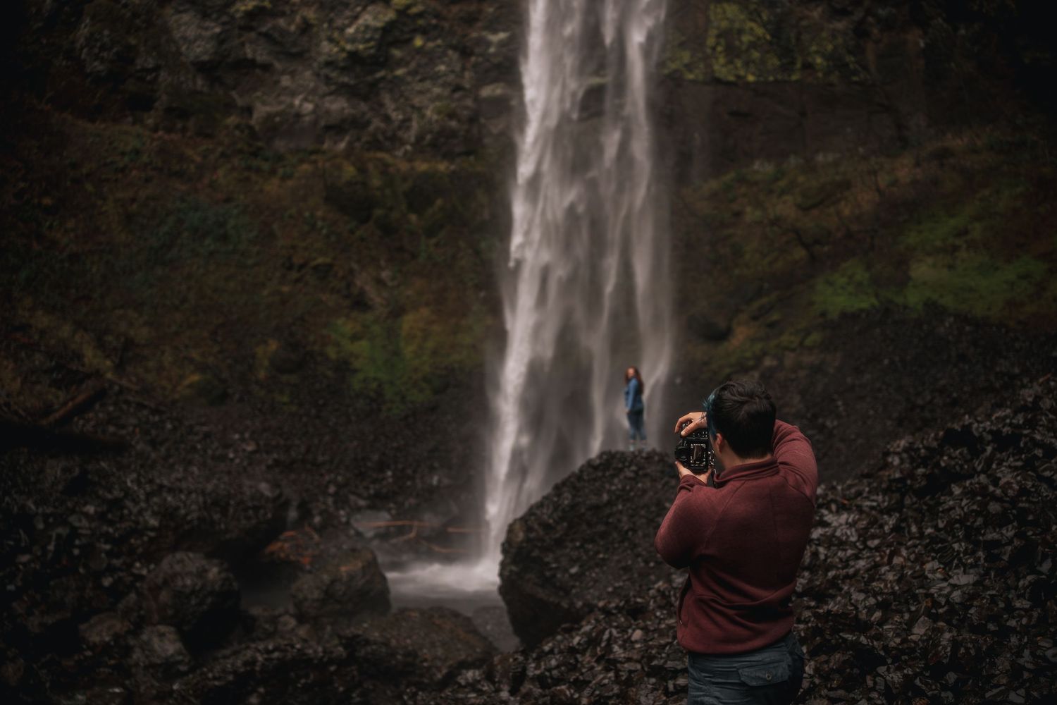 A photographer captures a subject posing on a rock in front of a waterfall in the Columbia River Gorge region of Oregon, near Portland.