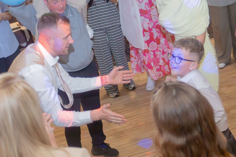 Man and boy sharing a fun dance moment on the dance floor at a First Holy Communion celebration party.