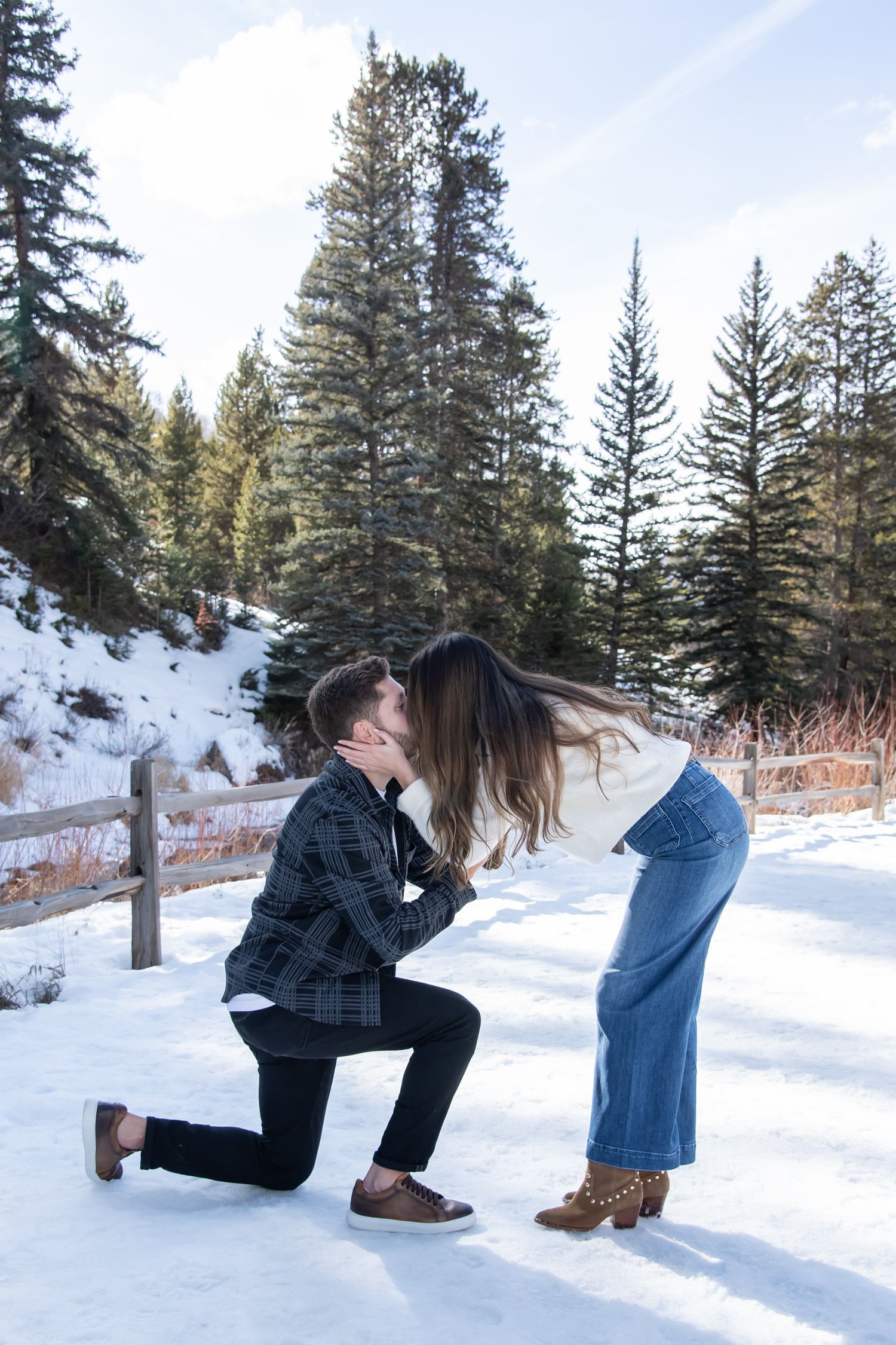 Man gets down on one knee in a beautiful surprise winter proposal with a stylish fashion couple in Vail Colorado