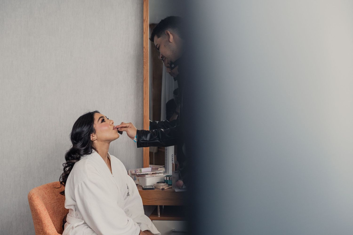 Four sequential images show a person in white loungewear sitting and relaxing against a gray wall.