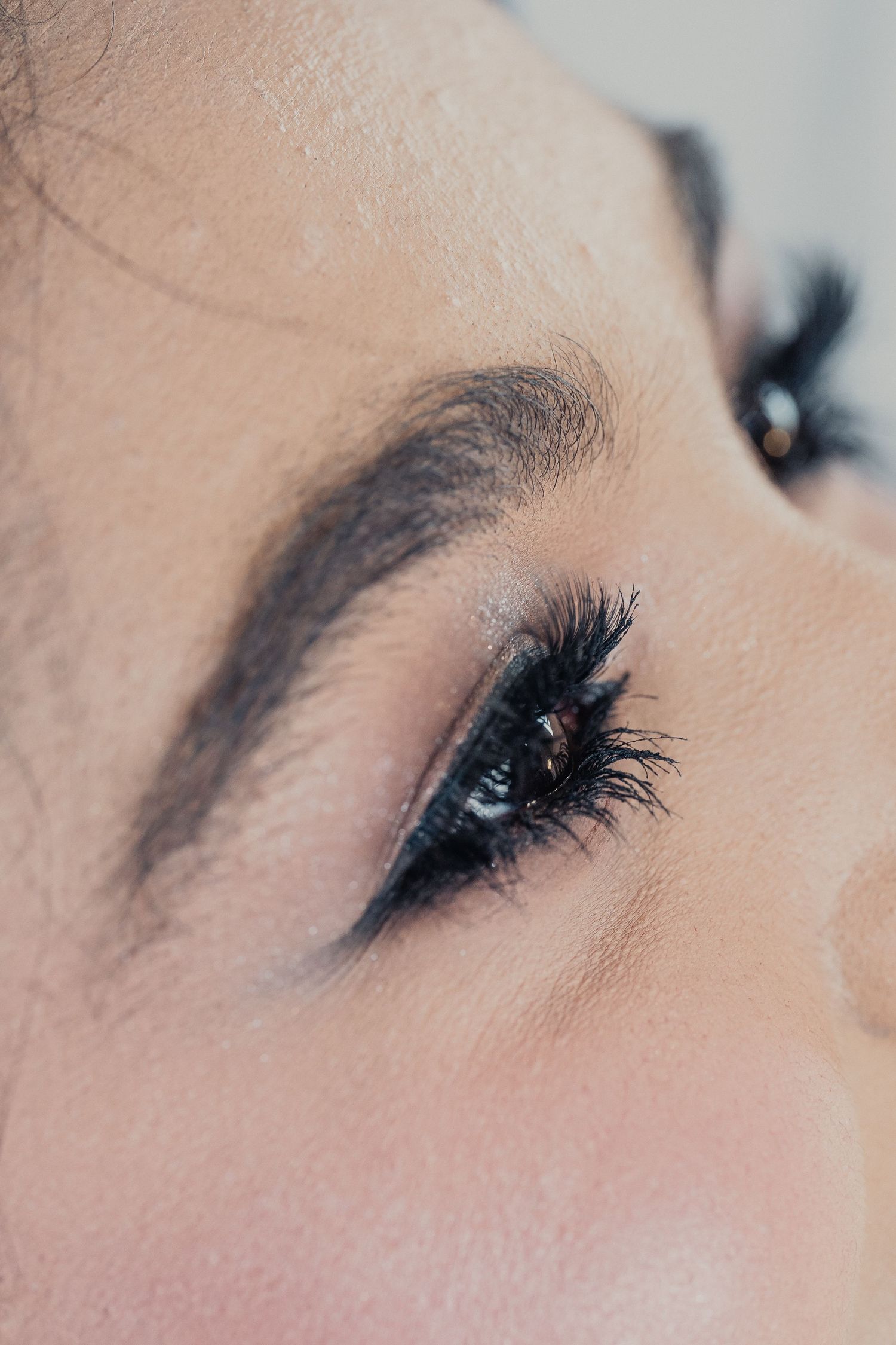 A close-up series of eye makeup looks showing dramatic black eyeliner and long lashes from different angles.