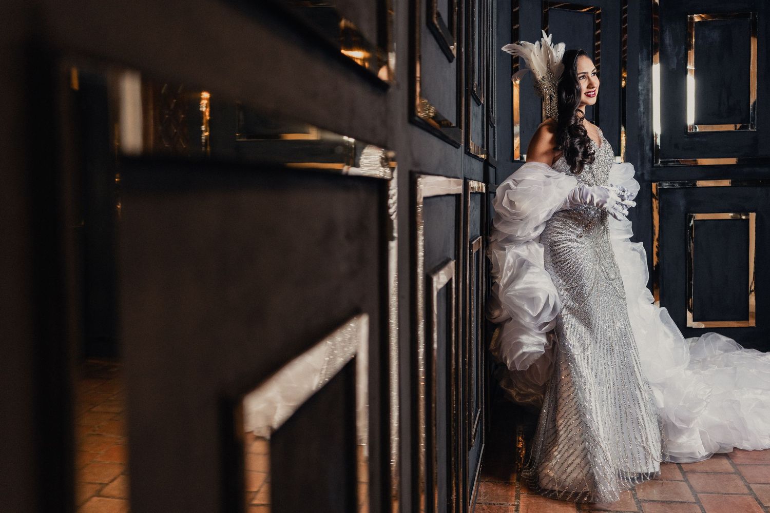 Artistic wedding photography showing elegant white dress against dark wooden paneled interior.