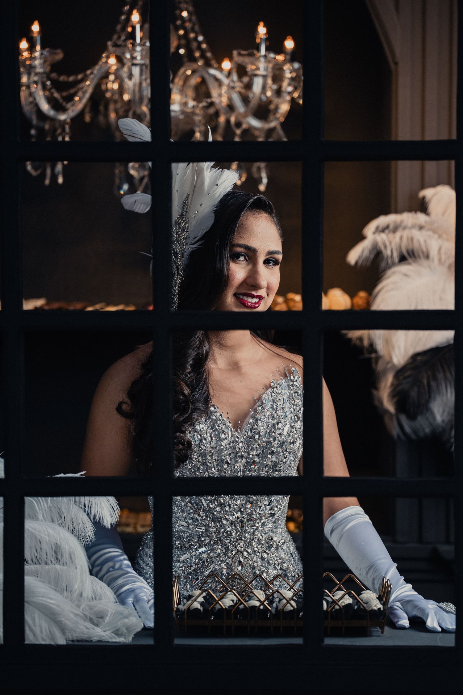 A dramatic wedding photo composition showing a sparkly silver dress through window panes in moody lighting.