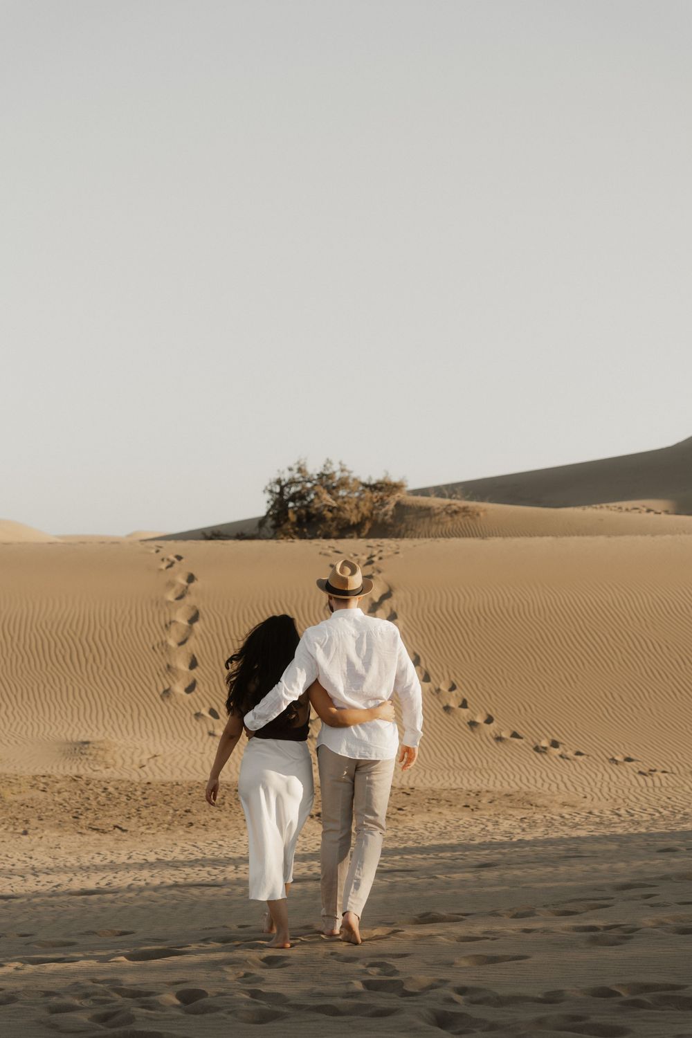 Cinematic destination photographer capturing a couple silhouette against a dramatic orange sky.