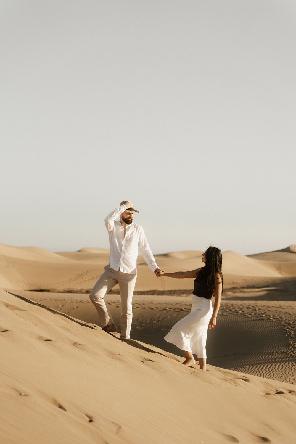 Close up of a romantic couple whispering during a cinematic sunset session in the dunes.