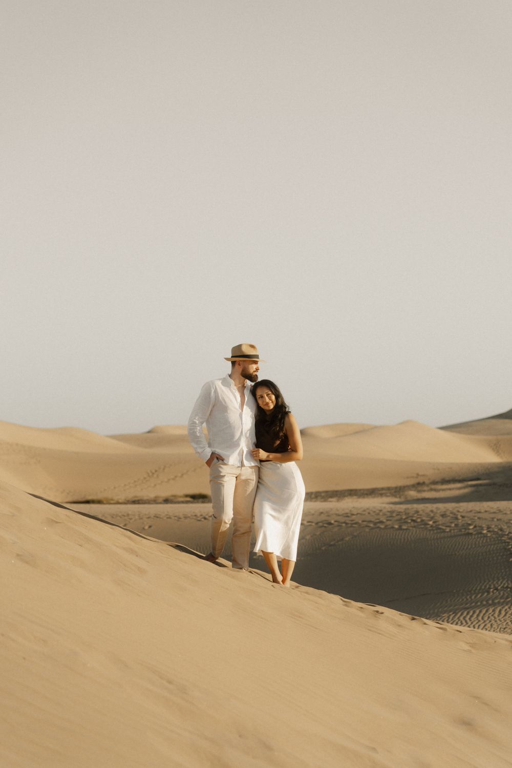 Editorial pre-wedding photography featuring an elegant couple in a minimalist desert setting.