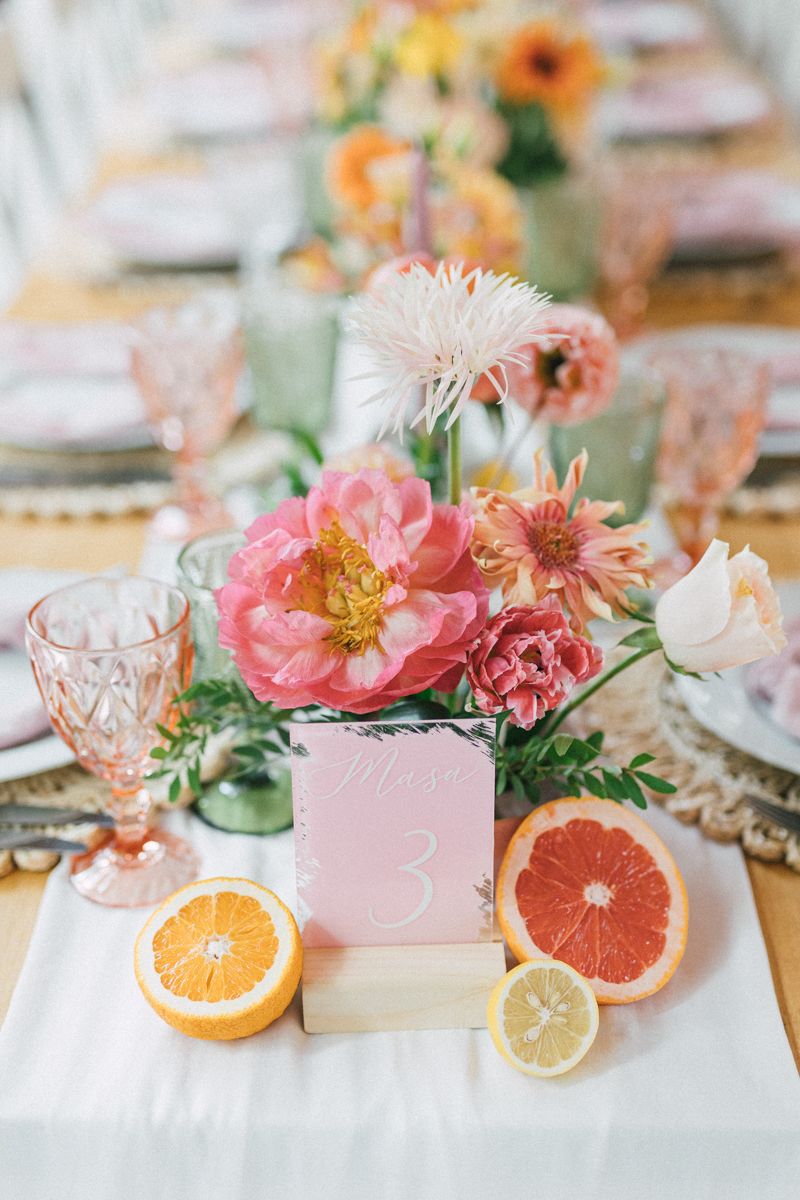 A citrus and pink floral tablescape with grapefruit slices and coral peonies.