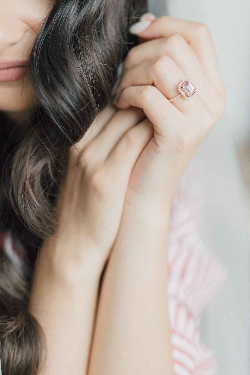 Close-up detail shot of hands showing an elegant engagement ring.