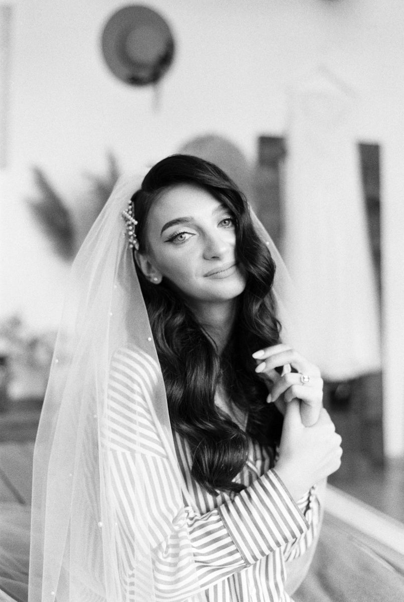 Black and white bridal portrait showcasing romantic waves and a striped dress.