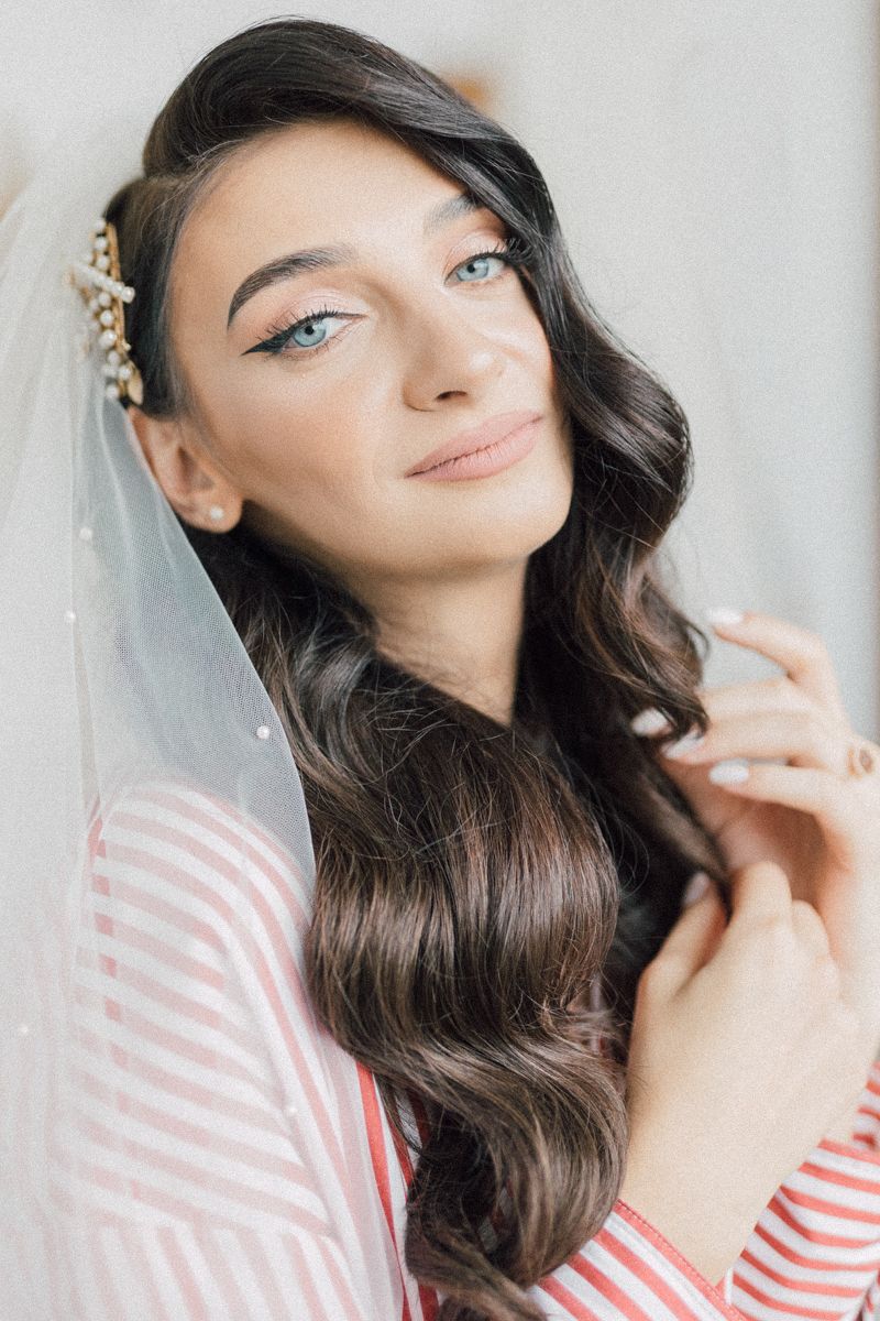 Bridal portrait featuring elegant pearl hair accessories and a soft tulle veil.