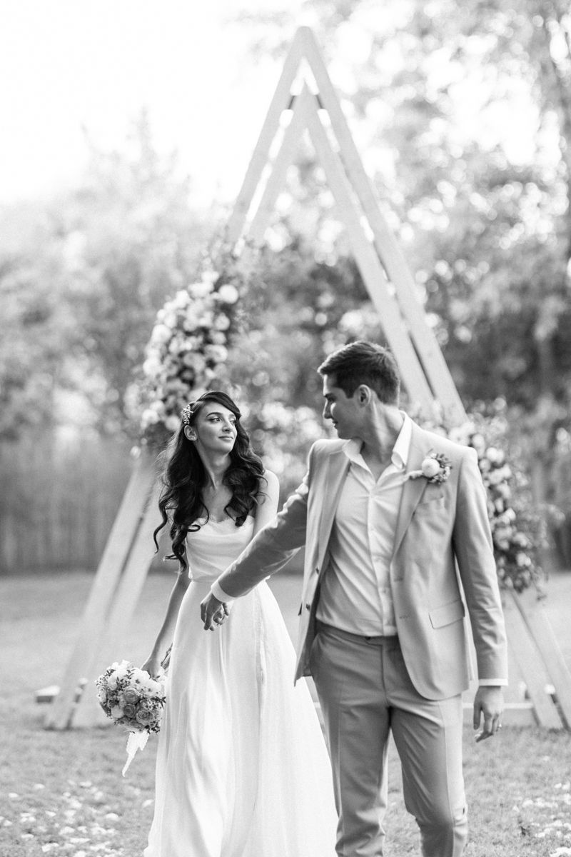 Joyful couple shares candid moments together during outdoor garden wedding photoshoot.