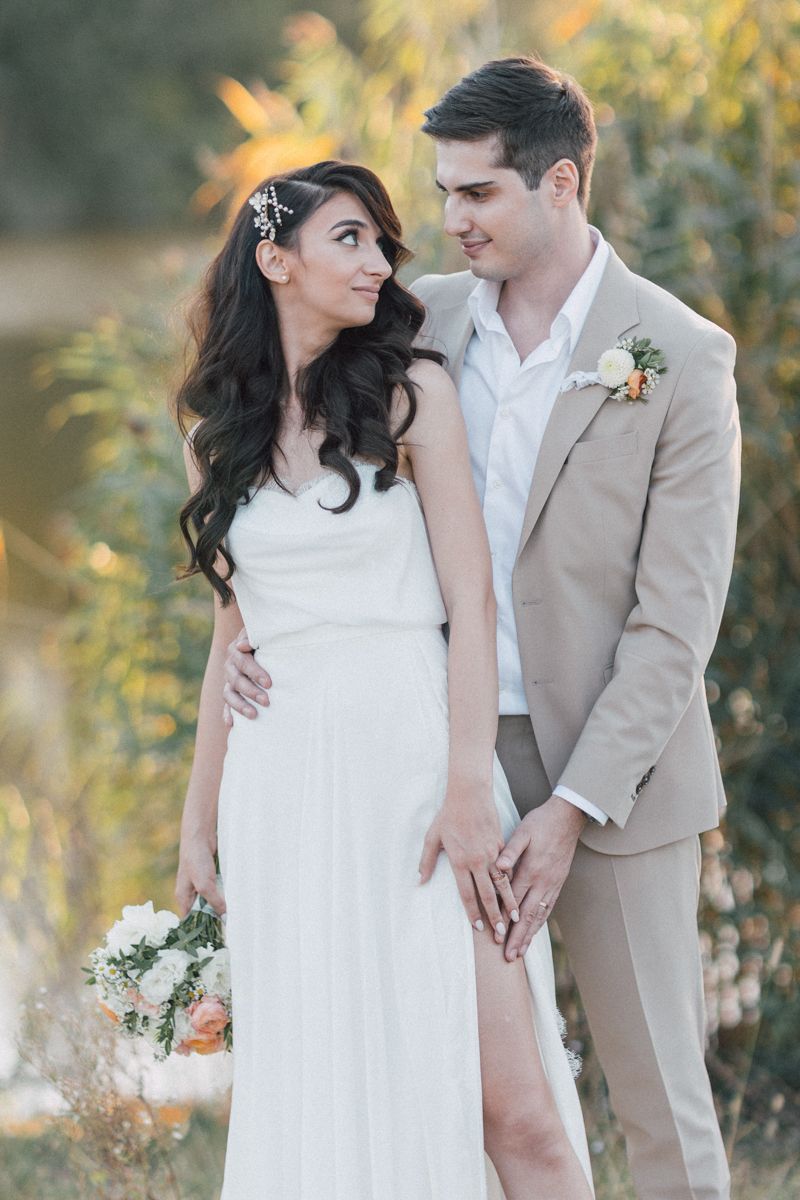 Romantic wedding portraits in a natural setting with soft golden light.