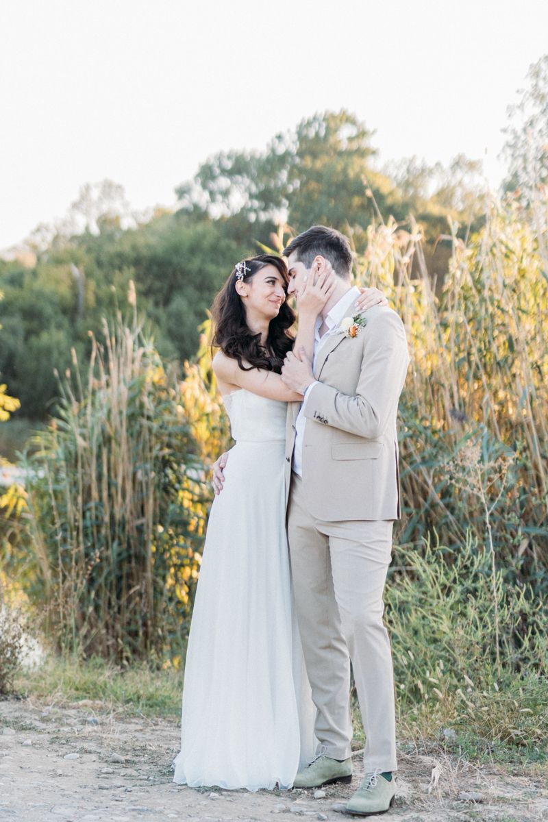 Wedding couple shares tender moments among wildflowers at sunset.