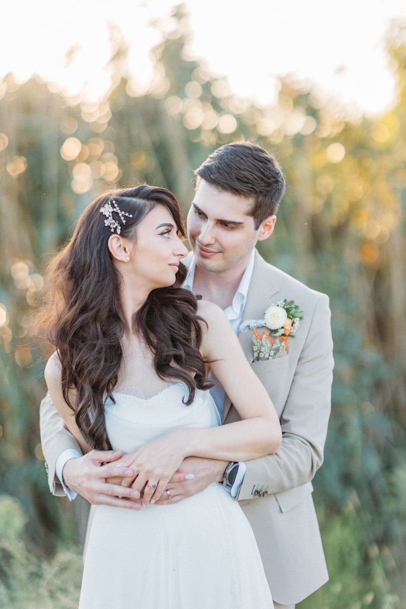 Newlyweds share tender moments during outdoor photo session with natural lighting.