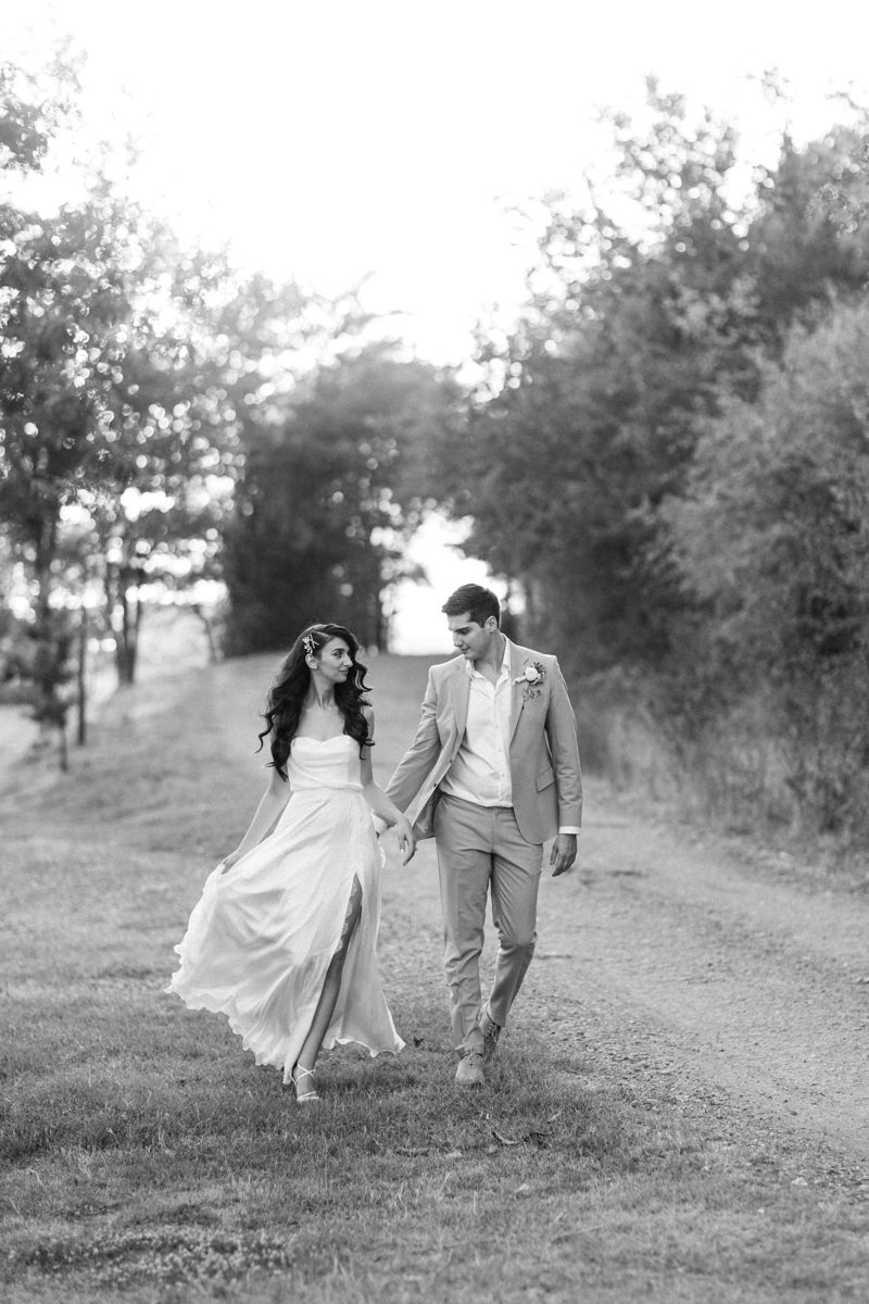 Black and white wedding photography capturing romantic moments on a rustic path.
