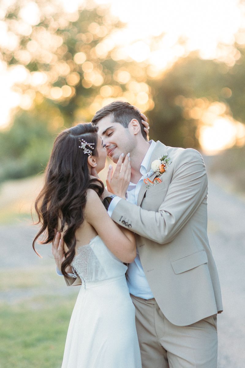 Intimate wedding photography with soft golden lighting and natural outdoor backdrop.