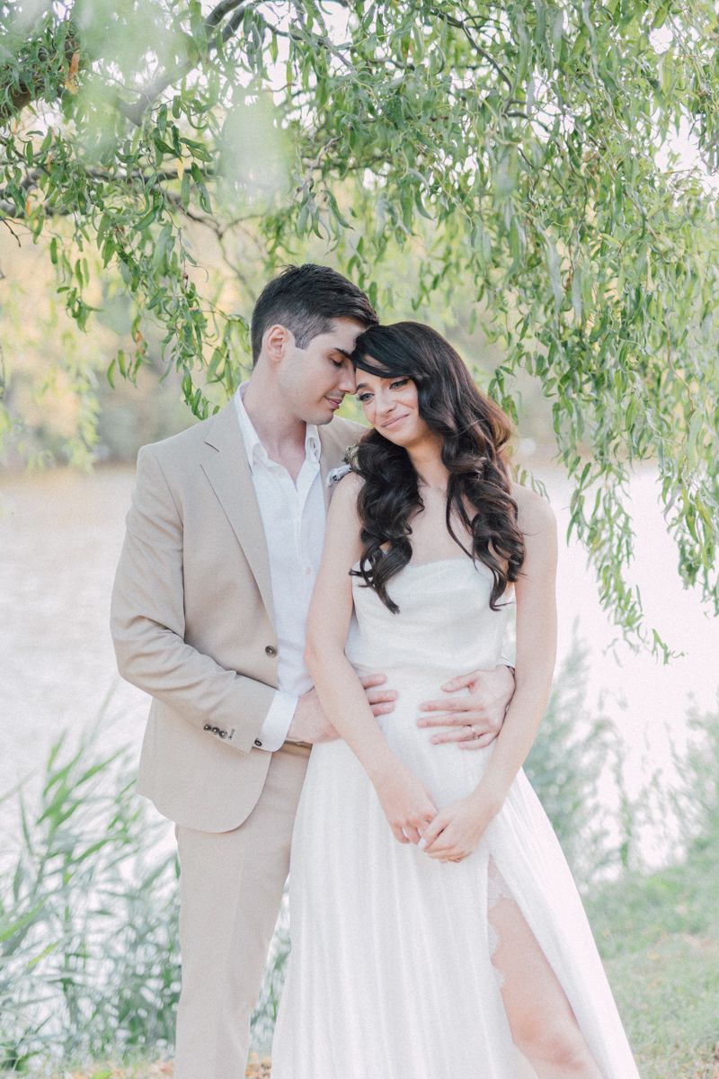 Dreamy wedding portraits under willow trees with soft pastel lighting.