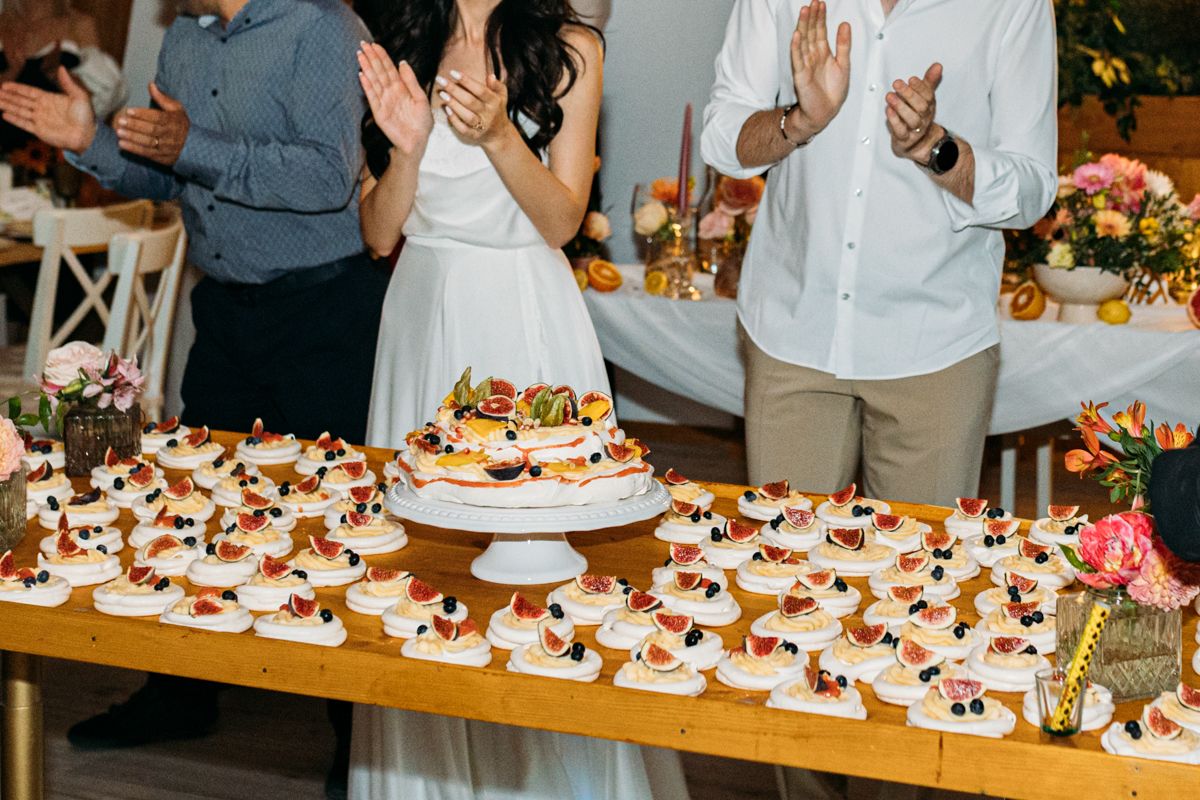 Wedding reception dessert table with rows of decorated cupcakes.