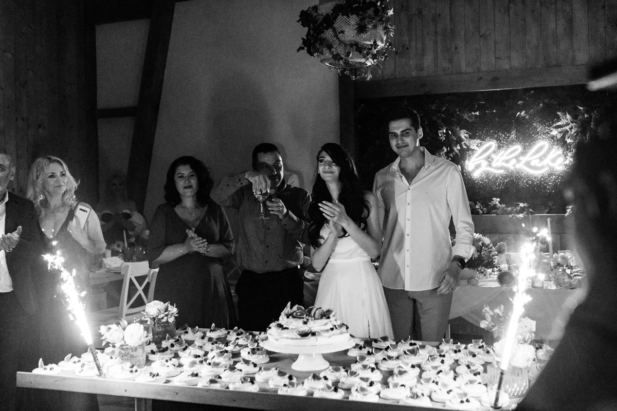 Wedding celebration with sparklers creating magical light effects in dark venue.