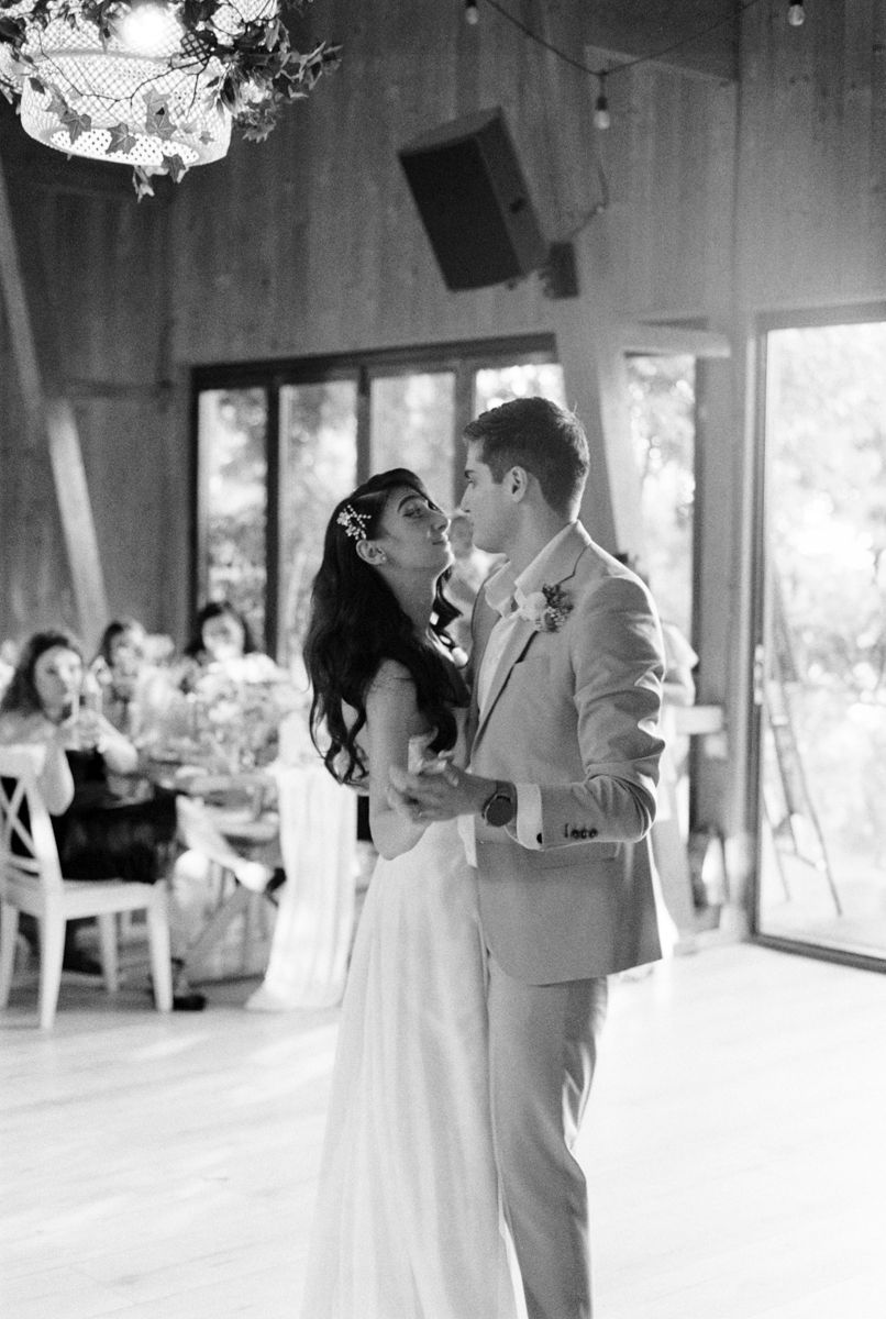A romantic first dance moment under crystal chandeliers in an elegant reception venue.