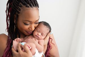 A tender moment between parent and newborn baby during an intimate studio photography session.