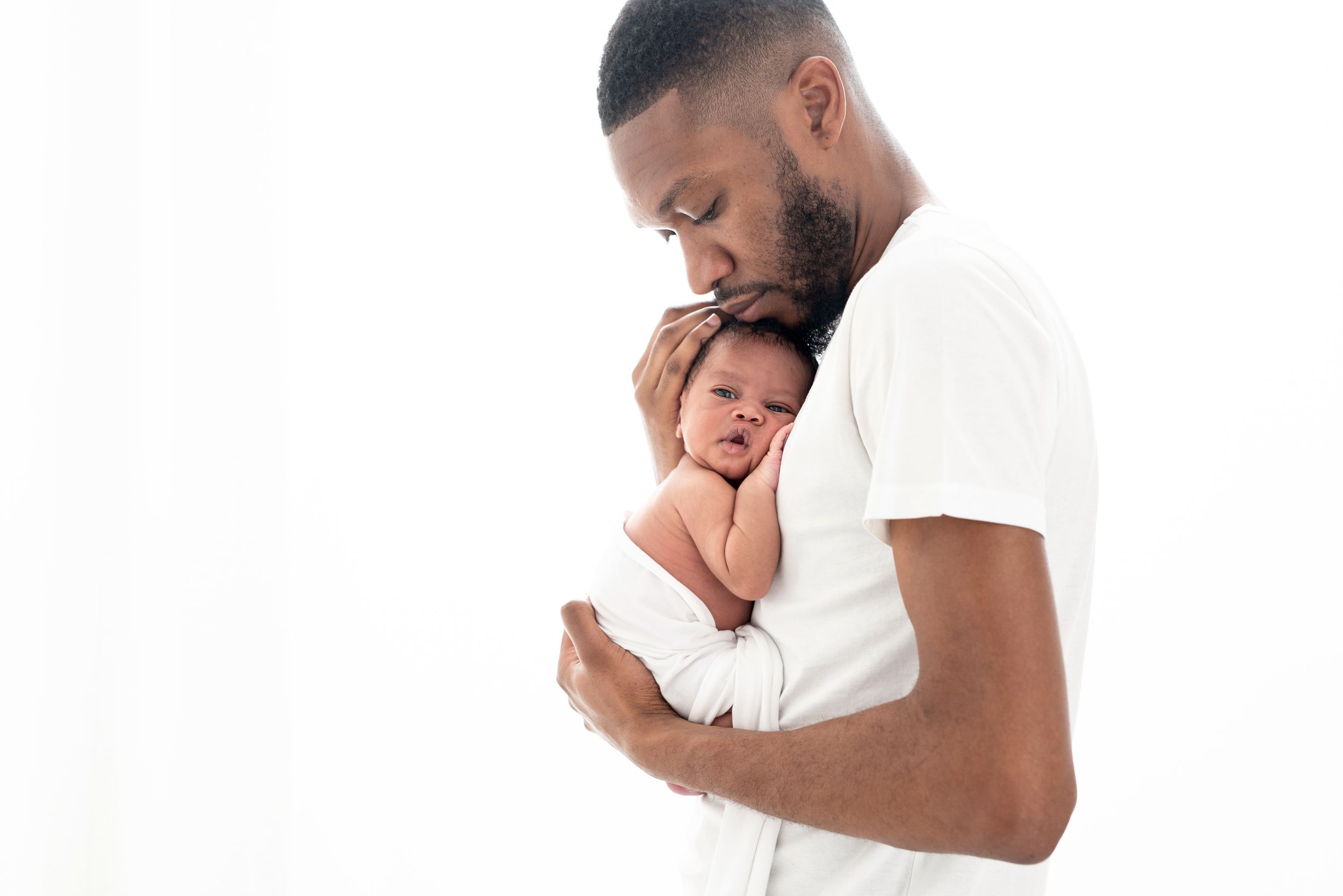 A series of tender moments between a parent and baby in white clothing against a light background.