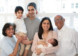 Multi-generational family members share loving moments together in a bright indoor setting.