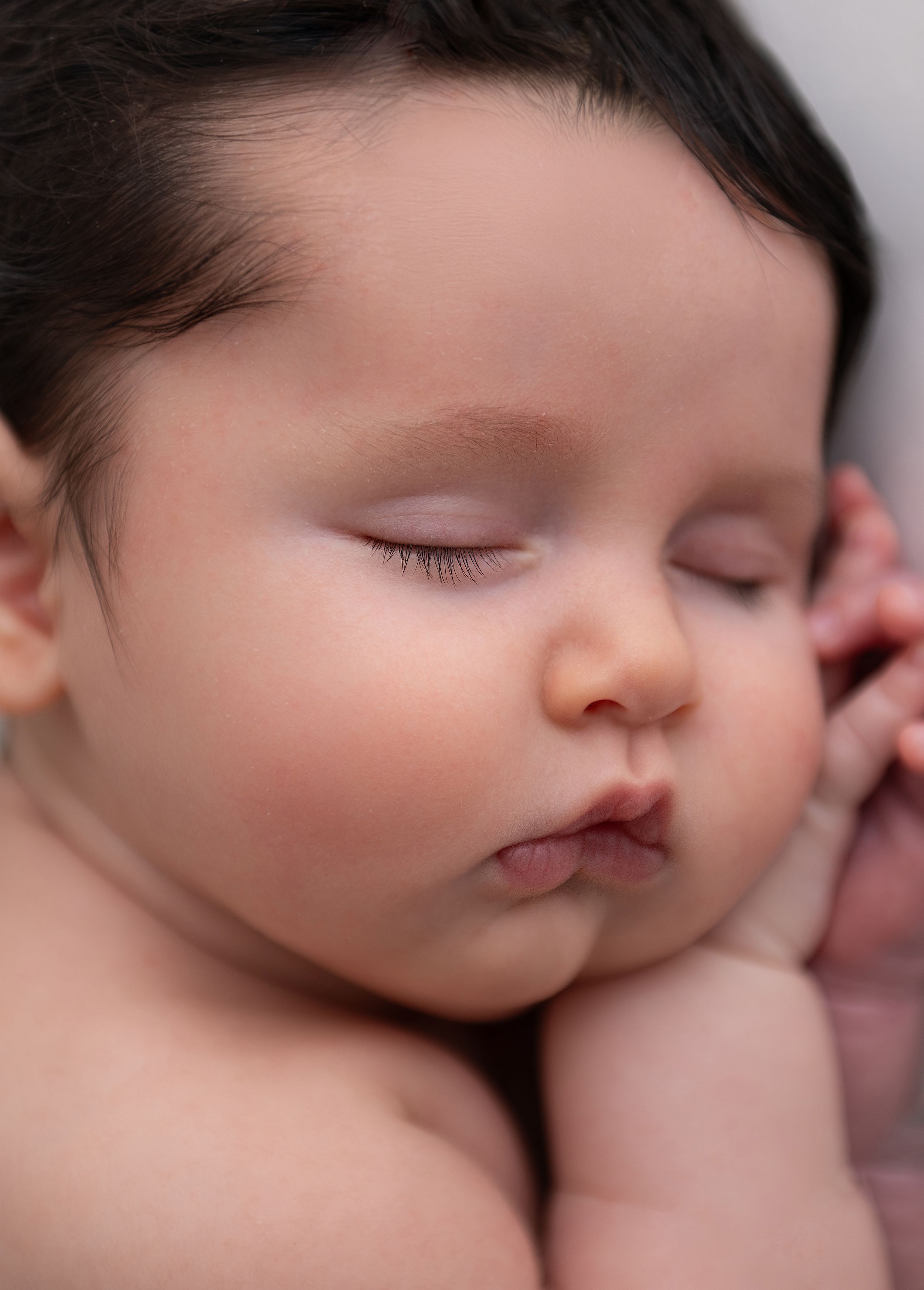 A sleeping infant's face shown in a series of close-up photos showing peaceful slumber and tranquility.