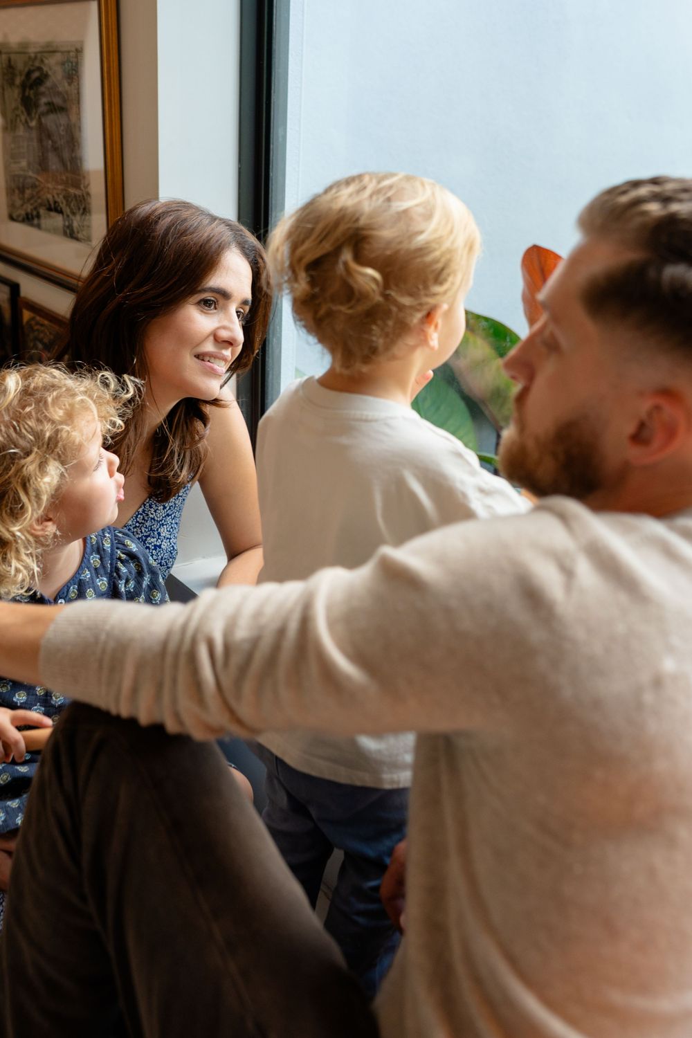 A family shares a tender moment together by a window in their home, creating a warm and intimate atmosphere.