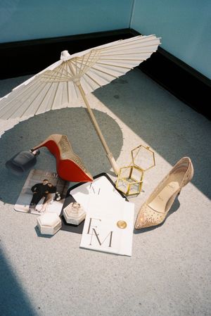 A sequence of still life photos showing shoes and a decorative paper umbrella arranged on a gray carpet.