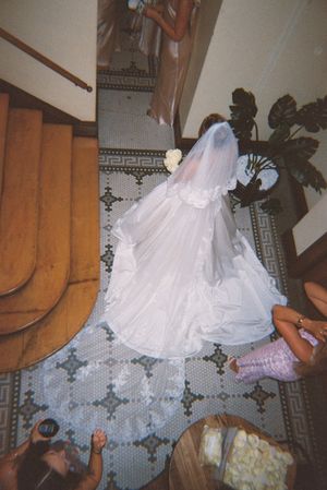 A series of photos showing a white wedding dress flowing down wooden stairs on a patterned carpet.