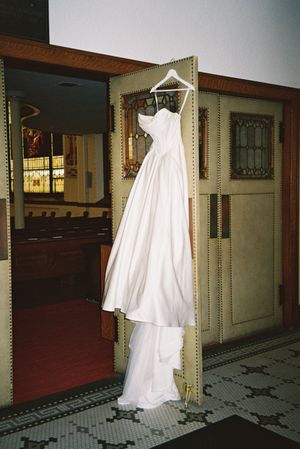 A spooky white ghost-like figure appears to float down a dimly lit vintage hallway with tiled floors and wooden doors.