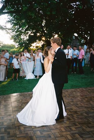 A sequence of wedding dance photos on an outdoor patio during sunset with guests watching in the background.