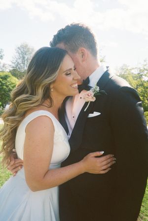 A tender moment between newlyweds as they share an intimate embrace outdoors on their wedding day.