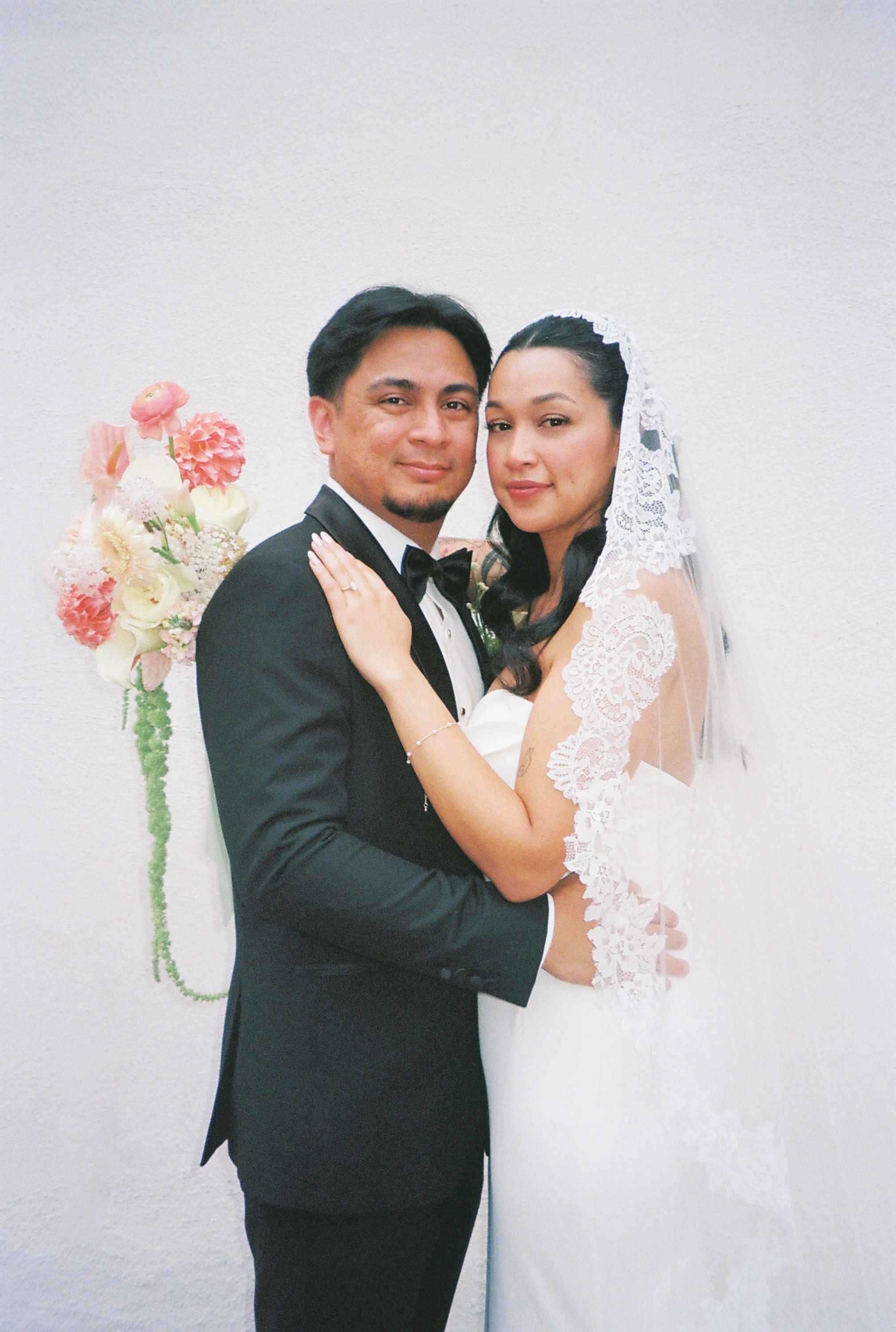 A series of wedding photos showing a bride and groom embracing against a light backdrop with pink floral arrangements.