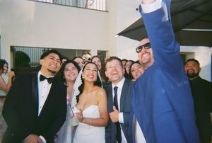 A wedding party poses together for a casual group photo during the celebration.