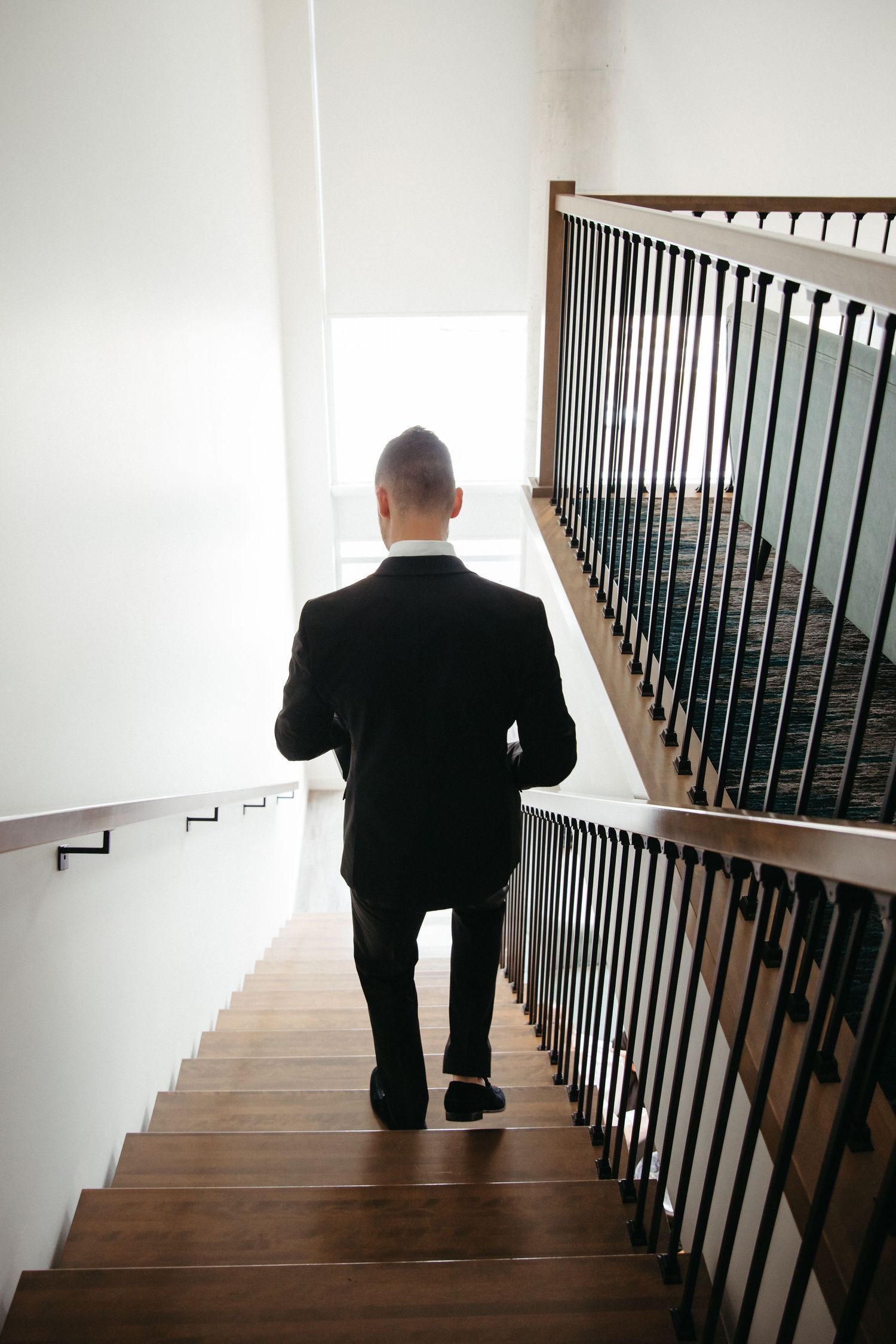 groom walks down stairs at CANVAS hotel suite loft in Moncton NB wedding photographer with full day service and two photographers luxury